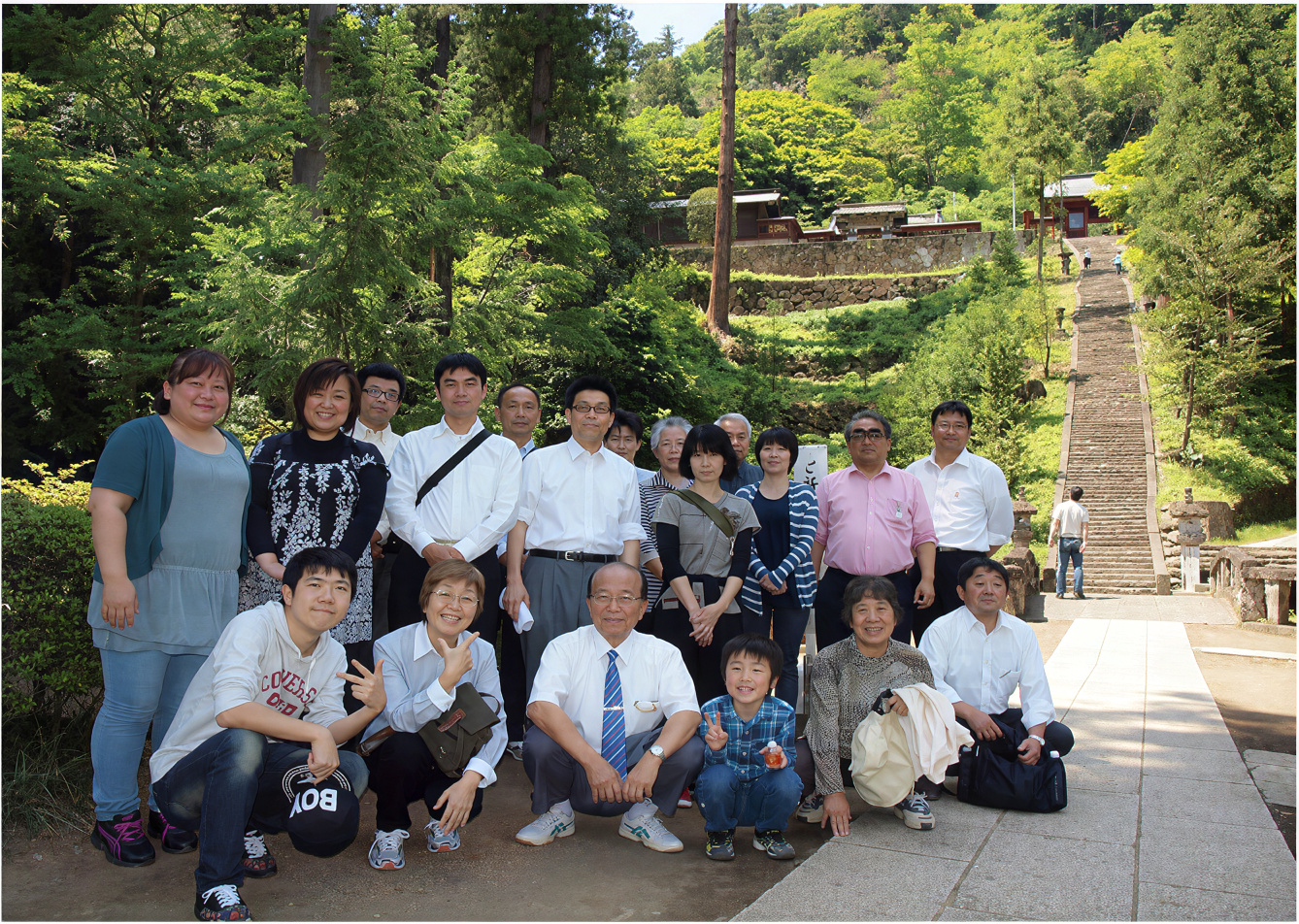 Sensei Masao Utsumi with students before the stone staircase of a sacred site in Japan
